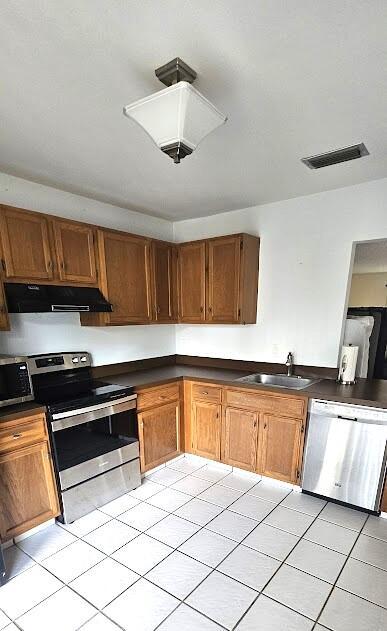 163 Pinto Palm Ct Unit 02, Royal Palm Beach, FL 33411 - kitchen with stainless steel appliances, a sink, under cabinet range hood, light tile patterned floors, and dark countertops