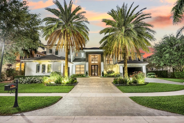 8388 Del Prado Dr, Delray Beach, FL 33446 - view of front facade with curved driveway, stucco siding, and a front lawn