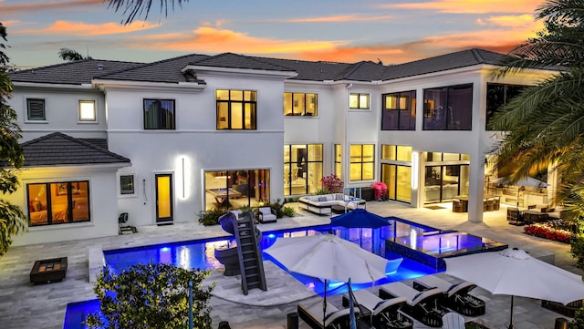 8388 Del Prado Dr, Delray Beach, FL 33446 - rear view of property with an outdoor living space with a fire pit, a tiled roof, an outdoor pool, and stucco siding