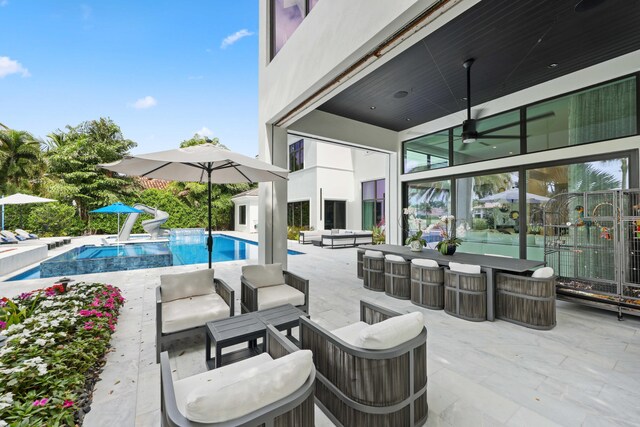 8388 Del Prado Dr, Delray Beach, FL 33446 - view of patio featuring outdoor lounge area, ceiling fan, and an outdoor pool