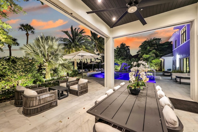 8388 Del Prado Dr, Delray Beach, FL 33446 - patio terrace at dusk with an outdoor living space, an outdoor pool, a patio, and ceiling fan