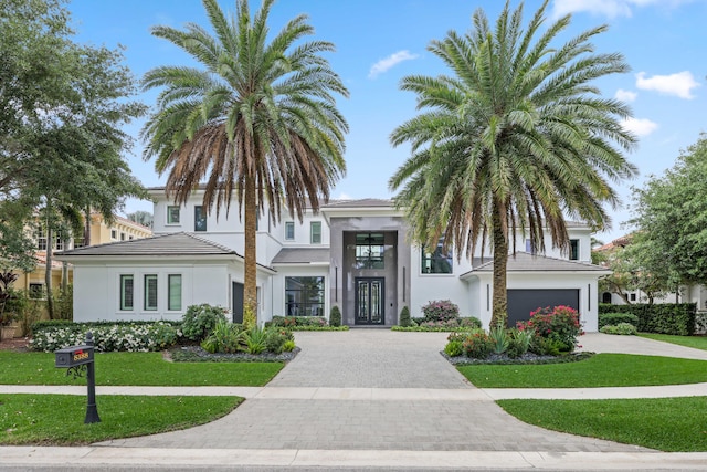 8388 Del Prado Dr, Delray Beach, FL 33446 - view of front of house featuring driveway, stucco siding, a front yard, and a garage