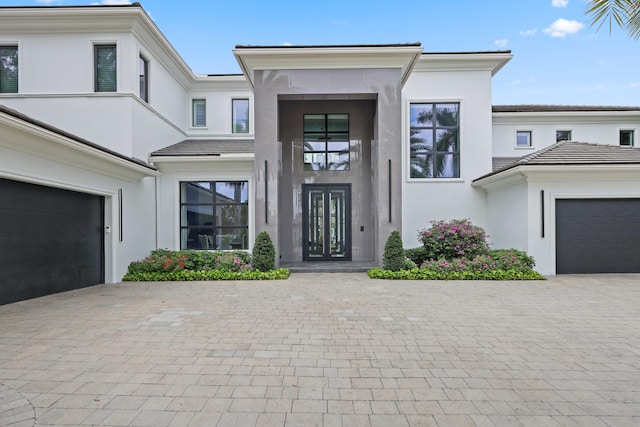 8388 Del Prado Dr, Delray Beach, FL 33446 - view of exterior entry with stucco siding, french doors, and decorative driveway