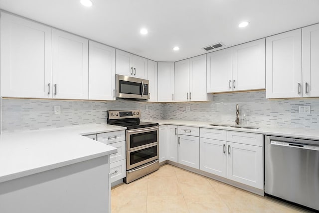kitchen featuring light countertops, a sink, appliances with stainless steel finishes, light tile patterned floors, and visible vents