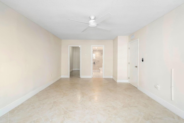 empty room featuring baseboards, visible vents, and a ceiling fan