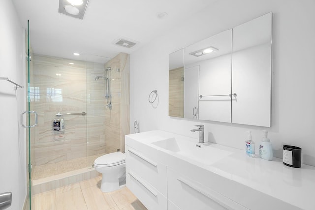 full bath with toilet, vanity, a shower stall, and visible vents