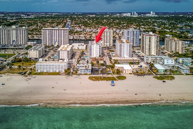 birds eye view of property featuring a view of city, a water view, and a beach view