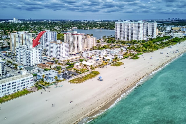 drone / aerial view featuring a view of the beach, a water view, and a view of city