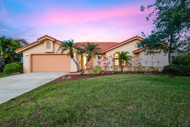 view of front of home with stucco siding, driveway, a garage, and a tiled roof