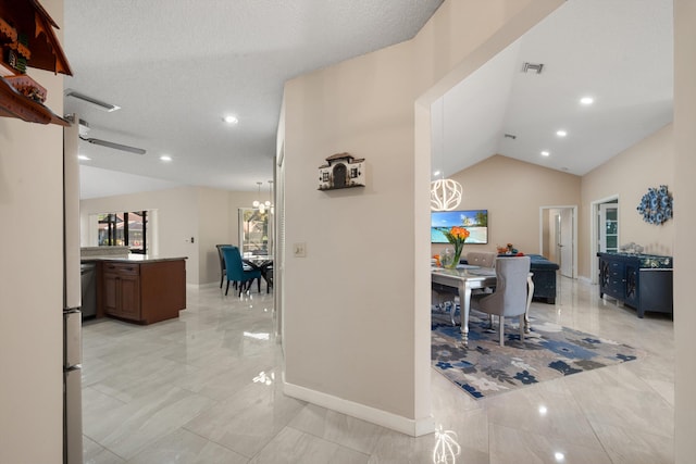 interior space featuring baseboards, lofted ceiling, a textured ceiling, and visible vents