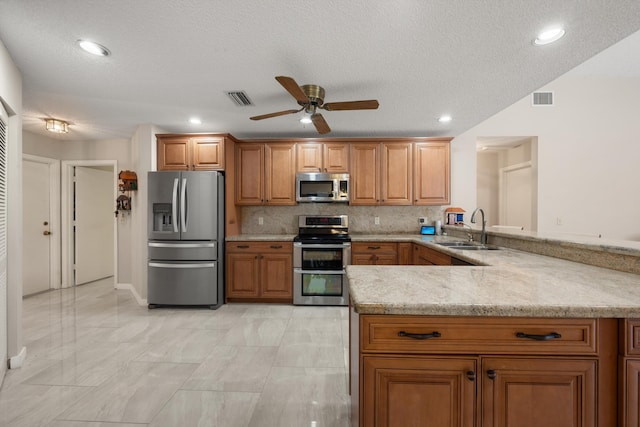 kitchen with a sink, stainless steel appliances, a peninsula, and visible vents
