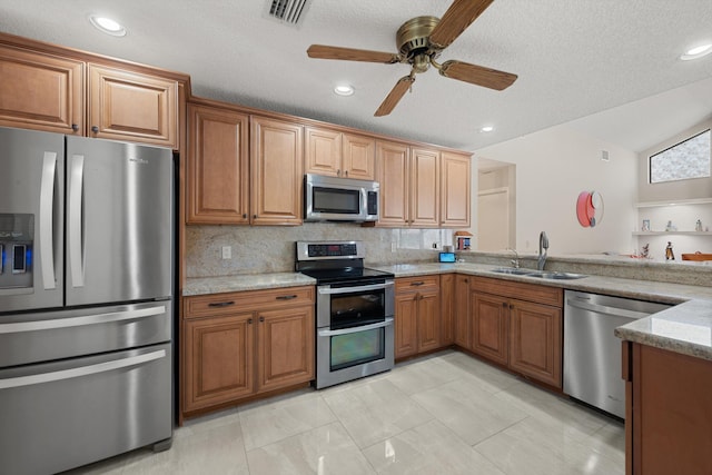 kitchen featuring brown cabinets, visible vents, a sink, and stainless steel appliances