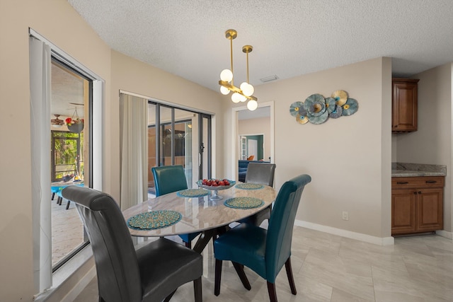 dining space with baseboards, a textured ceiling, and visible vents
