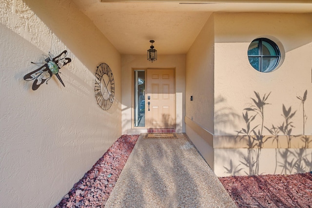 entrance to property featuring stucco siding