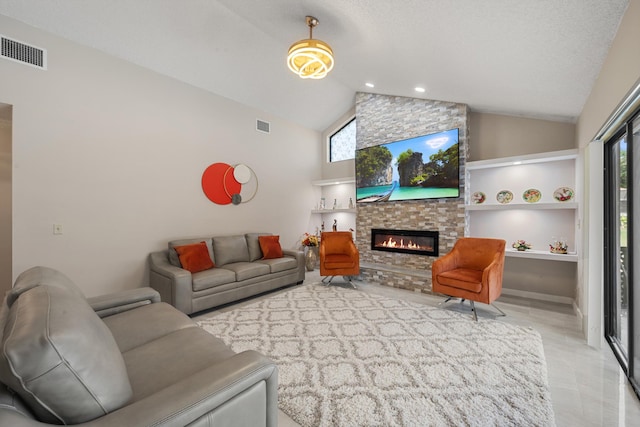 living area featuring a stone fireplace, visible vents, and plenty of natural light