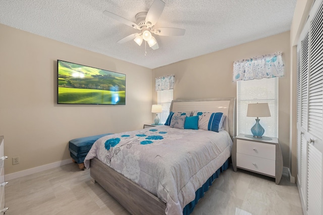 bedroom with baseboards, a closet, ceiling fan, and a textured ceiling