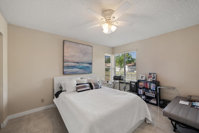 bedroom featuring a textured ceiling, baseboards, and ceiling fan