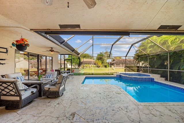 view of swimming pool with glass enclosure, a pool with connected hot tub, ceiling fan, and a patio