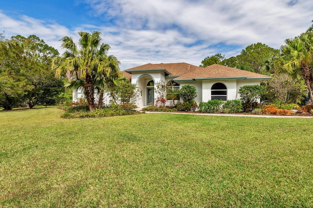 mediterranean / spanish home with stucco siding and a front yard