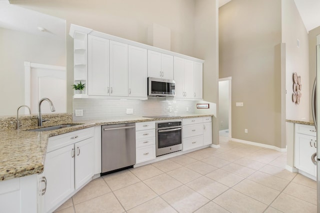 kitchen with backsplash, a sink, appliances with stainless steel finishes, and open shelves