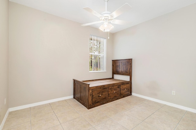 interior space with baseboards, ceiling fan, and light tile patterned floors