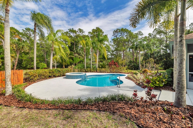 view of swimming pool featuring fence, a pool with connected hot tub, and a patio area