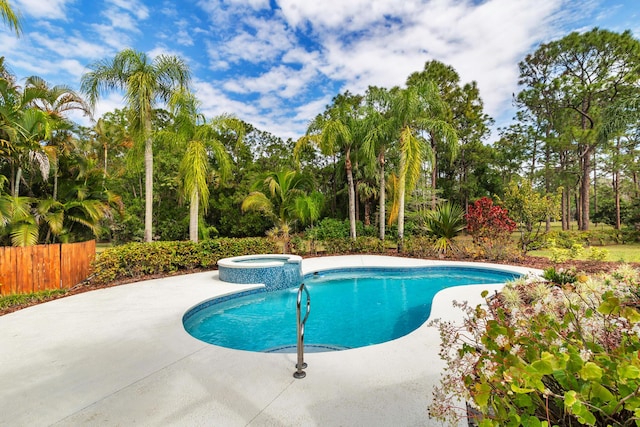 view of swimming pool featuring a patio, fence, and a pool with connected hot tub