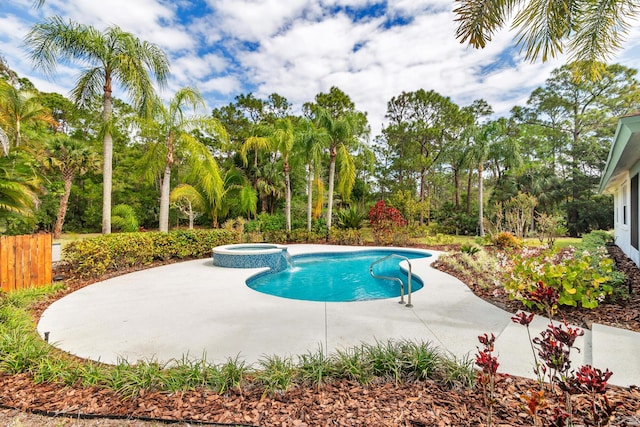 view of pool with fence, a pool with connected hot tub, and a patio area