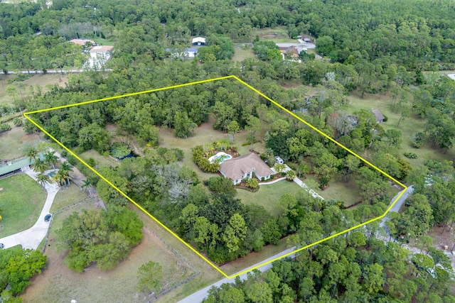 drone / aerial view featuring a wooded view