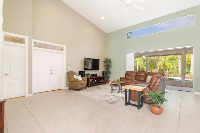 living room with a ceiling fan, light tile patterned floors, high vaulted ceiling, and baseboards