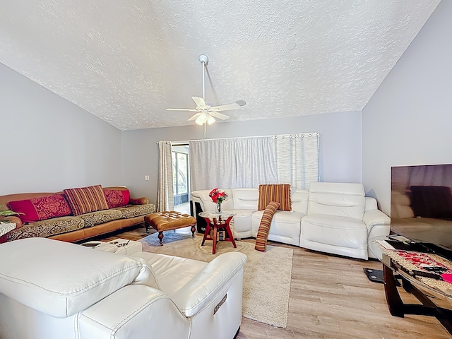 living area with a textured ceiling, lofted ceiling, wood finished floors, and a ceiling fan