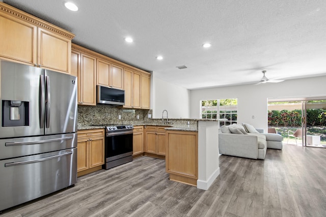 9448 Boca River Cir, Boca Raton, FL 33434 - kitchen with a sink, appliances with stainless steel finishes, a peninsula, open floor plan, and decorative backsplash