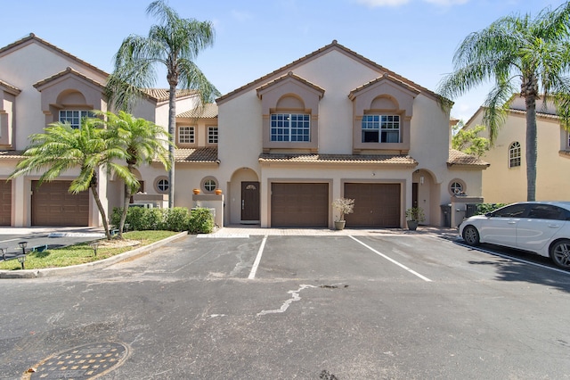 9448 Boca River Cir, Boca Raton, FL 33434 - mediterranean / spanish house with stucco siding, a tiled roof, and a garage