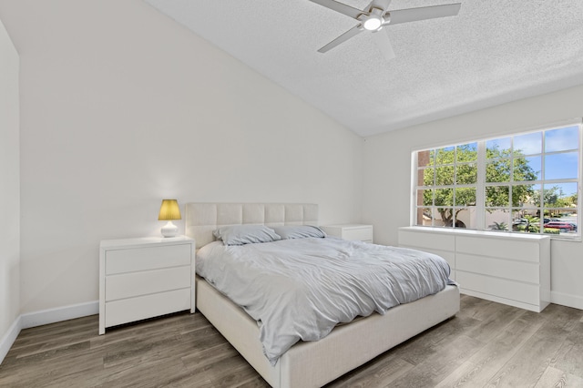9448 Boca River Cir, Boca Raton, FL 33434 - bedroom featuring a textured ceiling, baseboards, wood finished floors, a ceiling fan, and vaulted ceiling