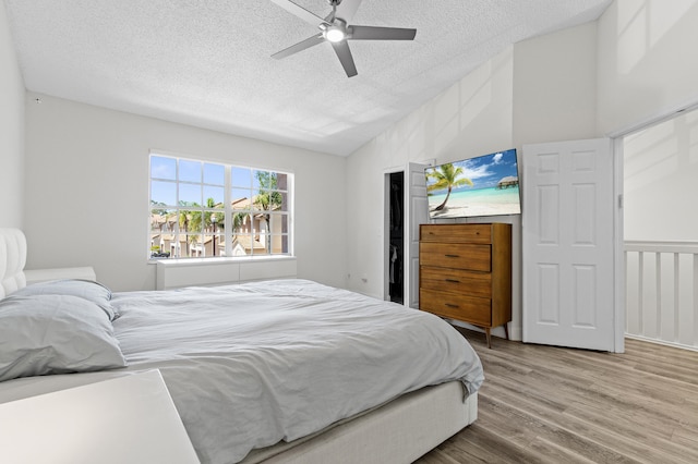 9448 Boca River Cir, Boca Raton, FL 33434 - bedroom featuring vaulted ceiling, a ceiling fan, light wood-style flooring, and a textured ceiling