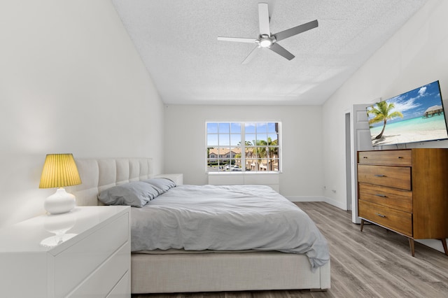 9448 Boca River Cir, Boca Raton, FL 33434 - bedroom with vaulted ceiling, baseboards, a textured ceiling, light wood-style floors, and ceiling fan
