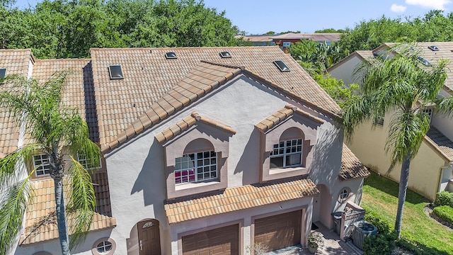 9448 Boca River Cir, Boca Raton, FL 33434 - mediterranean / spanish-style home with central AC unit, a tile roof, stucco siding, and an attached garage