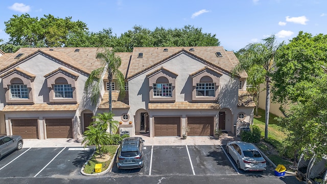 9448 Boca River Cir, Boca Raton, FL 33434 - view of front facade with uncovered parking, stucco siding, a tiled roof, and a garage
