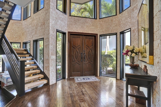 foyer featuring plenty of natural light, stairway, and hardwood / wood-style flooring