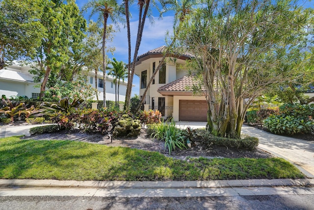 mediterranean / spanish home featuring stucco siding, a tile roof, and a front yard