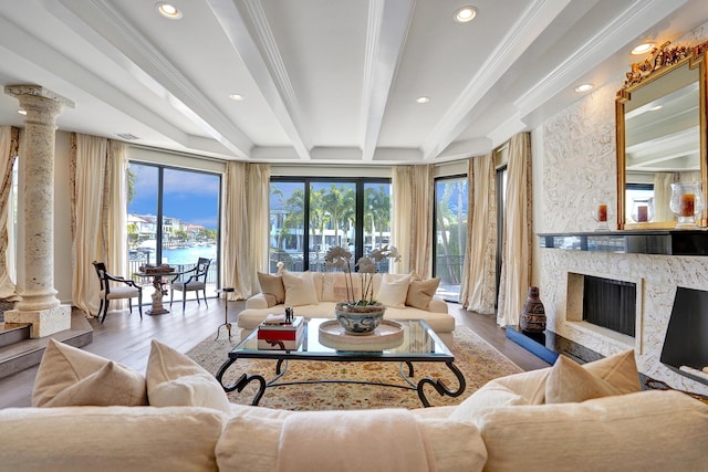 living room with ornate columns, beamed ceiling, a high end fireplace, and a wealth of natural light