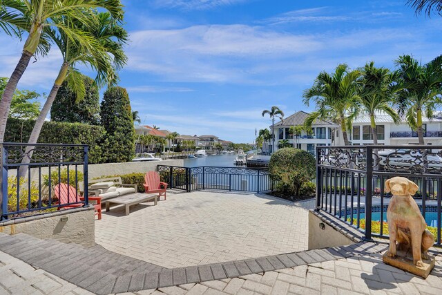 view of patio / terrace with a fenced in pool and a water view