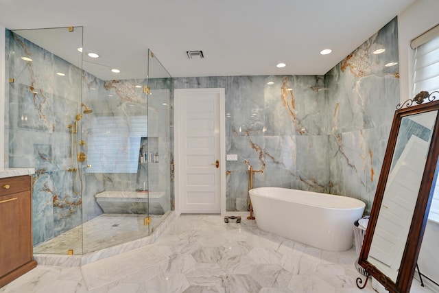 full bathroom with a marble finish shower, a freestanding bath, marble finish floor, and tile walls