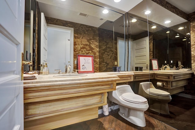 bathroom with vanity, visible vents, recessed lighting, toilet, and wood finished floors