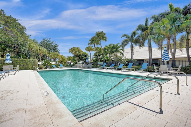 community pool with fence and a patio