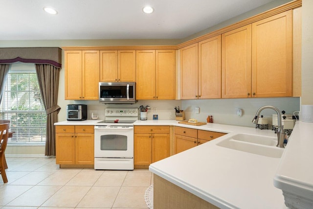 9686 SW Glenbrook Dr, Port Saint Lucie, FL 34987 - kitchen featuring light countertops, stainless steel microwave, a sink, light tile patterned flooring, and white electric range