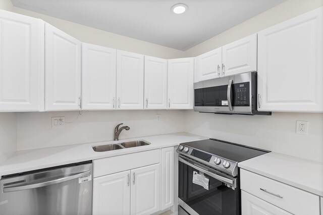 361 Normandy H, Delray Beach, FL 33484 - kitchen featuring stainless steel appliances, a sink, white cabinets, light countertops, and recessed lighting