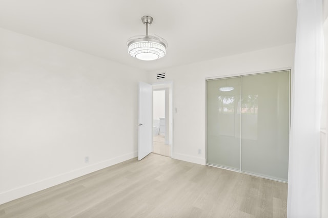 361 Normandy H, Delray Beach, FL 33484 - unfurnished bedroom featuring light wood-type flooring, baseboards, and a closet