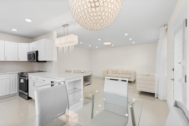 361 Normandy H, Delray Beach, FL 33484 - kitchen featuring stainless steel appliances, white cabinetry, light countertops, recessed lighting, and a peninsula