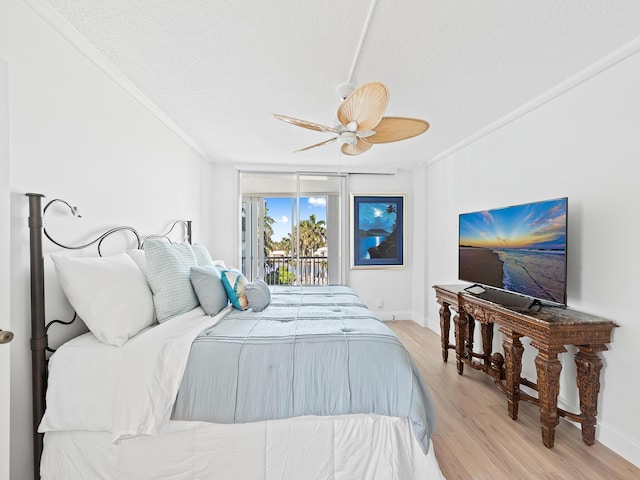 bedroom with baseboards, access to exterior, a textured ceiling, and light wood-style floors